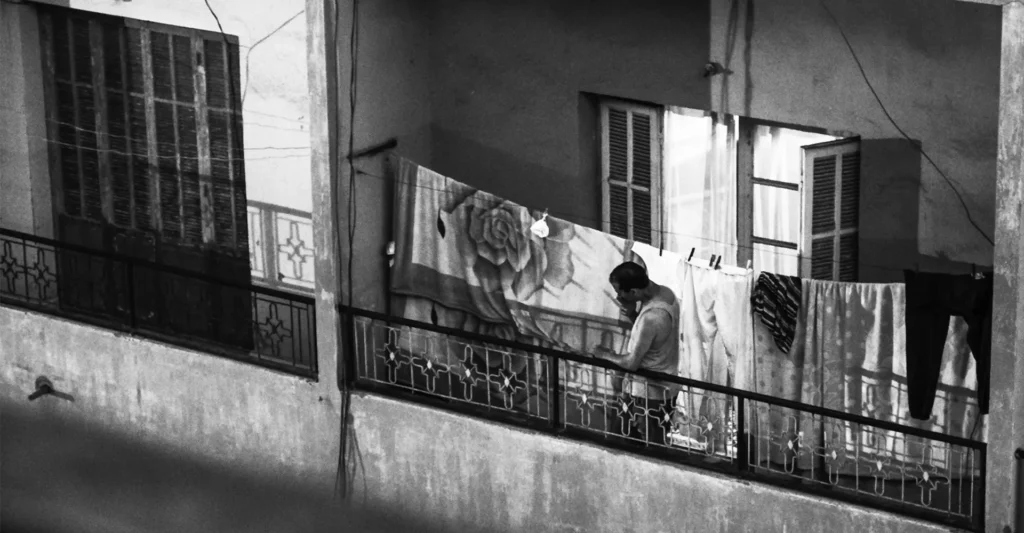 Homme fumant une cigarette sur un balcon à Marrakech pendant le Ramadan – photographie de Laïd Liazid